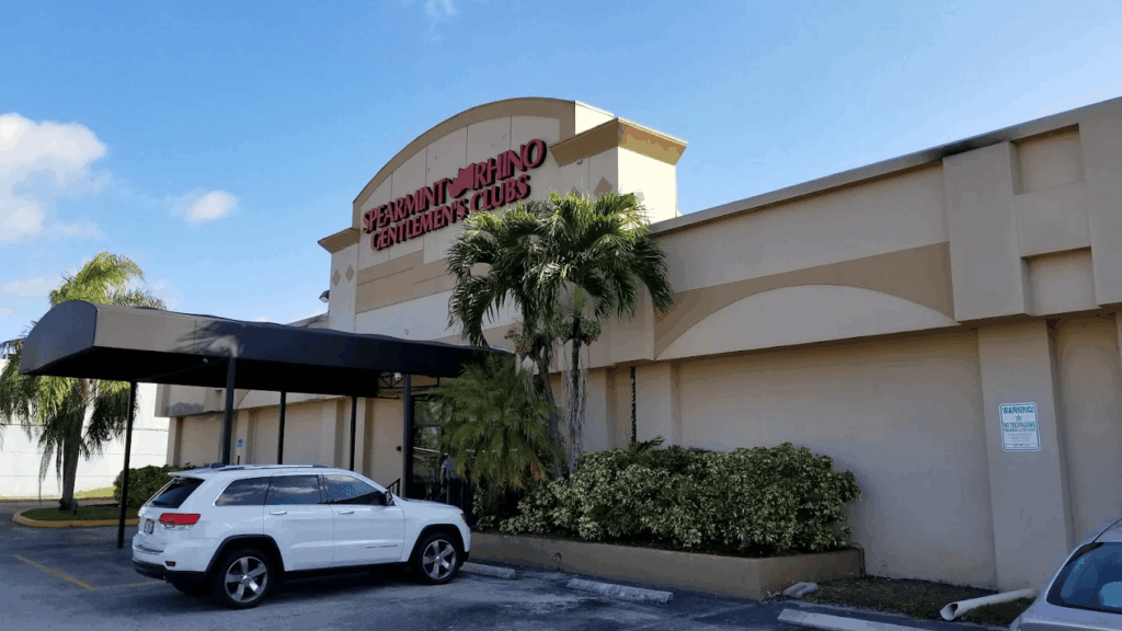 Stylish guests arriving at a luxury gentlemen's club in West Palm Beach with valet service and a welcoming VIP entrance.